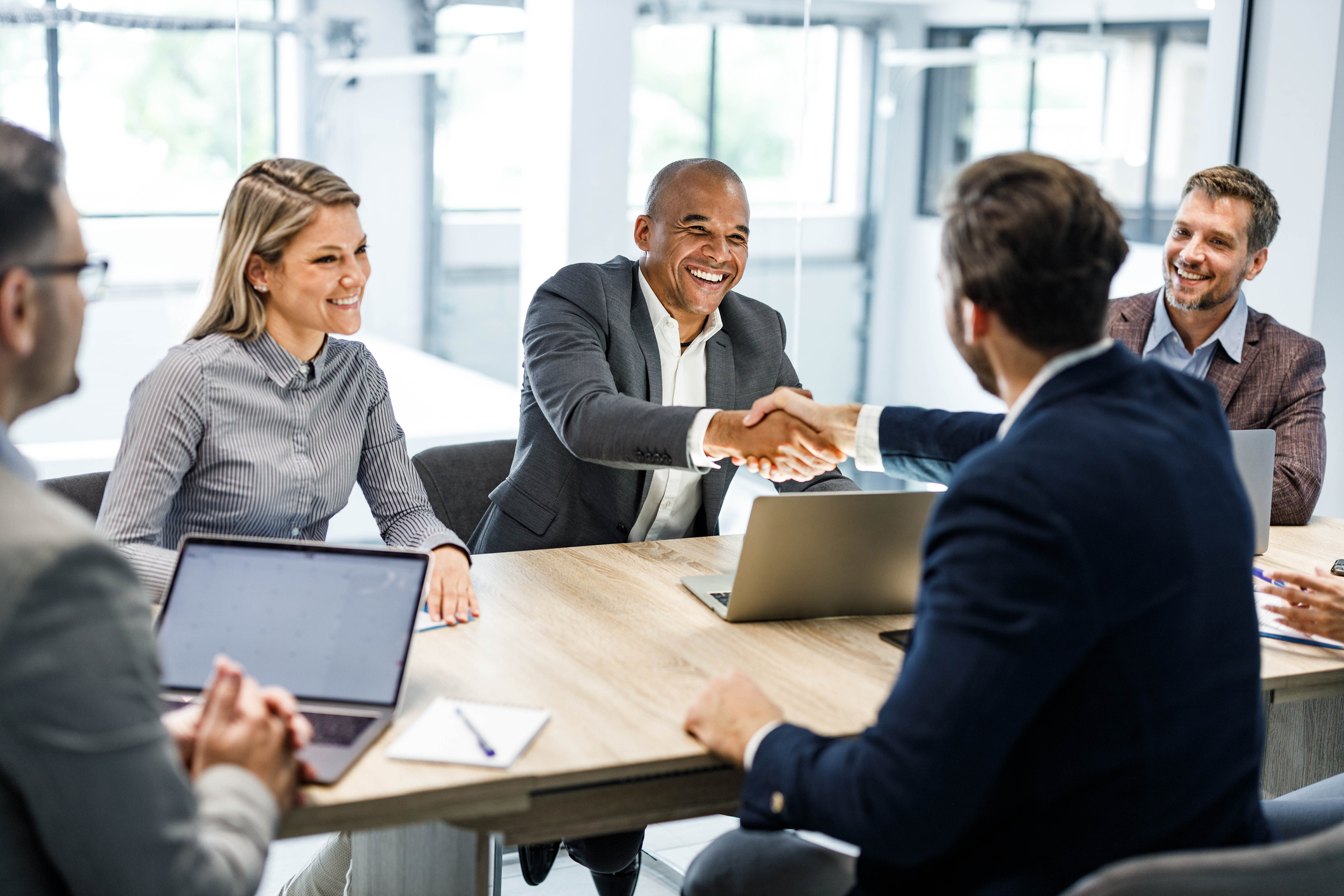 Happy businessmen shaking hands on a meeting in the office.